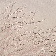 Abstracte zandpatronen door terugtrekkend water op strand bij eb, Schotland
