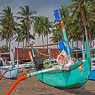 Kleurrijke Indonesische jukungs, houten uitlegger-kano's op het strand van Madewi aan de Indische Oceaan op Bali, Indonesië