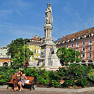 Toeristen poseren voor standbeeld van Walther von der Vogelweide op de Piazza Walther / Waltherplatz in Bolzano, Dolomieten, Italië
