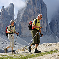 Koppel bergwandelaars bewonderen de Tre Cime di Lavaredo / Drei Zinnen, Dolomieten, Italië
