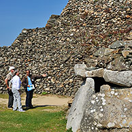 Toeristen met gids bezoeken toegang tot een van de kamers van de Cairn van Barnenez, een megalithisch monument nabij Plouezoc'h, Finistère is een grafheuvel uit het Neolithicum, Bretagne, Frankrijk