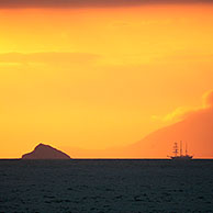 Zeilschip bij zonsondergang voor het eiland Santiago, Galapagos
