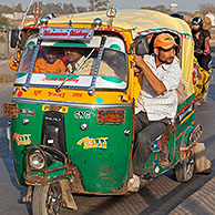 Overvolle tuktuk, gemotoriseerde riksja tijdens druk verkeer te Agra, Uttar Pradesh, India