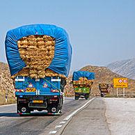 Zwaar beladen vrachtwagens met hooibalen op autosnelweg in Iran