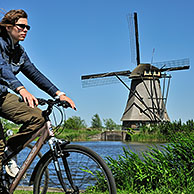 Fietser en achtkantige poldermolen, windmolen te Kinderdijk, Nederland

