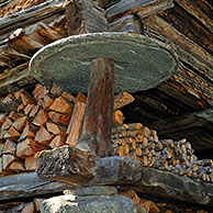 Detail van traditionele graanschuur met platte ronde steen om te verhinderen dat ratten en muizen bij het graan geraken, Wallis, Zwitserland
