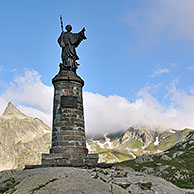 Standbeeld van Bernhard van Menton / Sint Bernard in de mist op de Grote Saint- Bernardpas in de Alpen, Zwitserland
